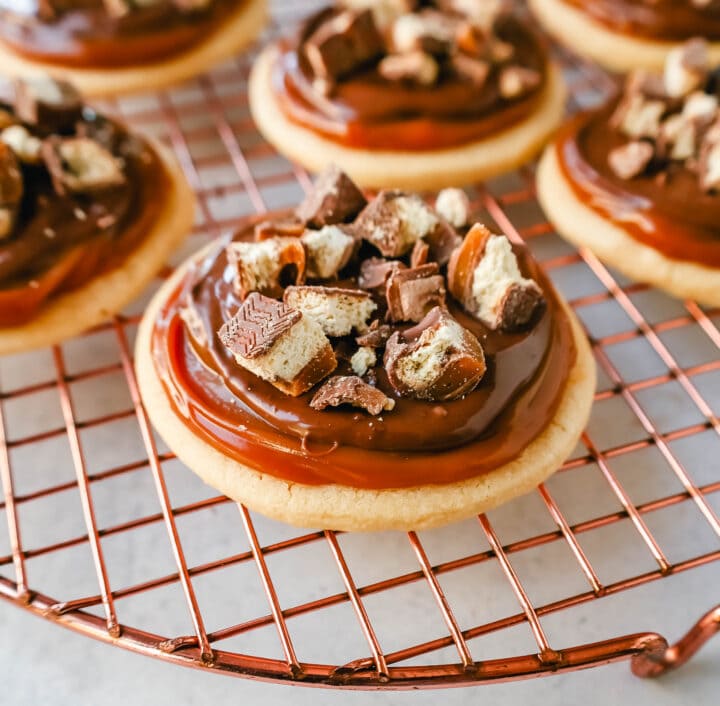 Twix Cookies made with soft sugar shortbread topped with rich caramel and milk chocolate and sprinkled with chopped Twix candy bars. These Millionaire Cookies are the best chocolate caramel shortbread cookie!