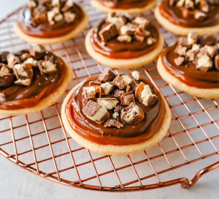 Twix Cookies made with soft sugar shortbread topped with rich caramel and milk chocolate and sprinkled with chopped Twix candy bars. These Millionaire Cookies are the best chocolate caramel shortbread cookie!