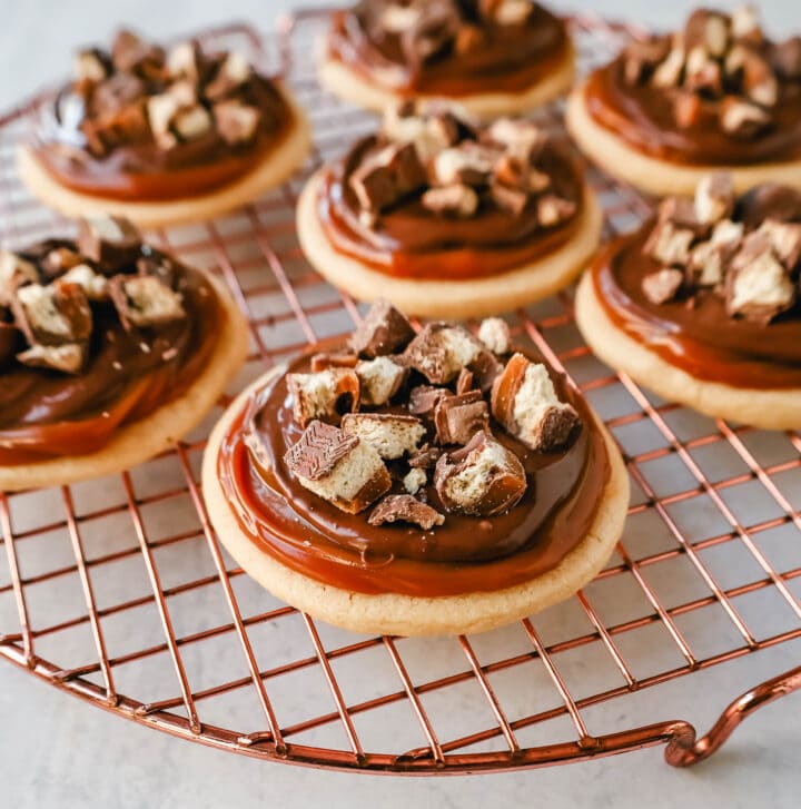  Twix Cookies made with soft sugar shortbread topped with rich caramel and milk chocolate and sprinkled with chopped Twix candy bars. These Millionaire Cookies are the best chocolate caramel shortbread cookie!