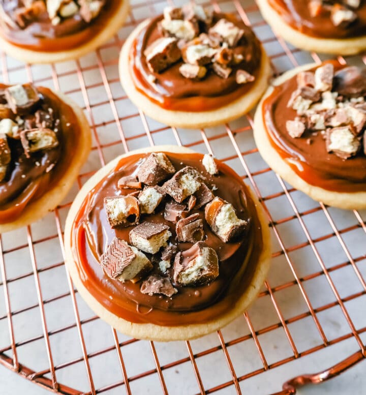 Twix Cookies made with soft sugar shortbread topped with rich caramel and milk chocolate and sprinkled with chopped Twix candy bars. These Millionaire Cookies are the best chocolate caramel shortbread cookie!