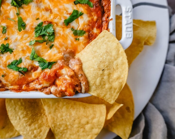 This is the best bean dip recipe ever! This is such an easy bean and cheese dip made with creamy beans, sour cream, cream cheese, taco seasoning, hot sauce, and lots of Mexican cheese! This easy bean dip is the best appetizer recipe. 