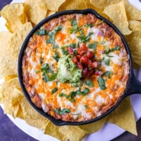 This is the best bean dip recipe ever! This is such an easy bean and cheese dip made with creamy beans, sour cream, cream cheese, taco seasoning, hot sauce, and lots of Mexican cheese! This easy bean dip is the best appetizer recipe.