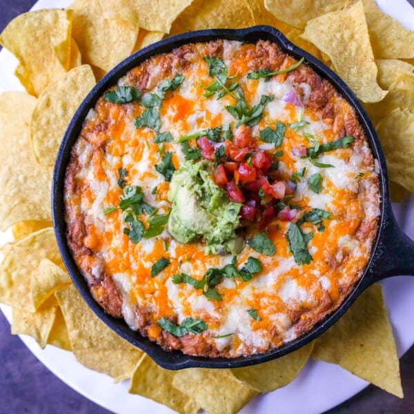 This is the best bean dip recipe ever! This is such an easy bean and cheese dip made with creamy beans, sour cream, cream cheese, taco seasoning, hot sauce, and lots of Mexican cheese! This easy bean dip is the best appetizer recipe. 