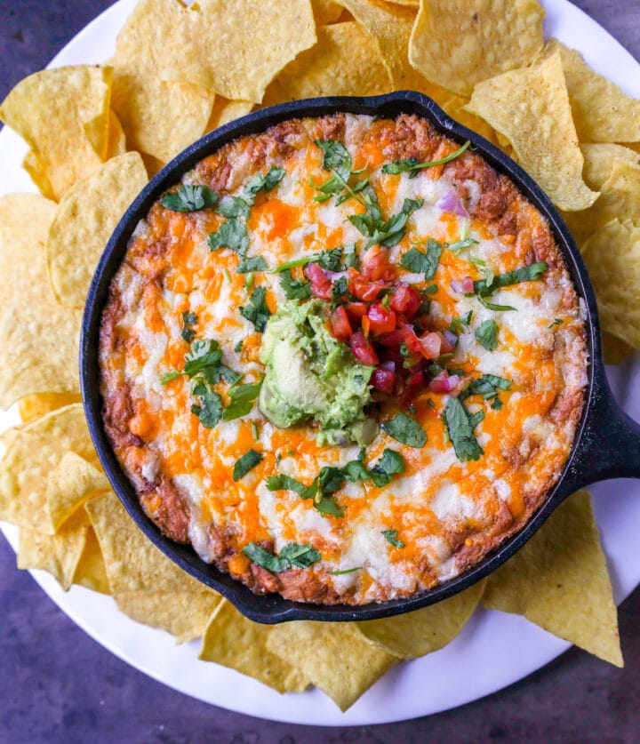 This is the best bean dip recipe ever! This is such an easy bean and cheese dip made with creamy beans, sour cream, cream cheese, taco seasoning, hot sauce, and lots of Mexican cheese! This easy bean dip is the best appetizer recipe. 