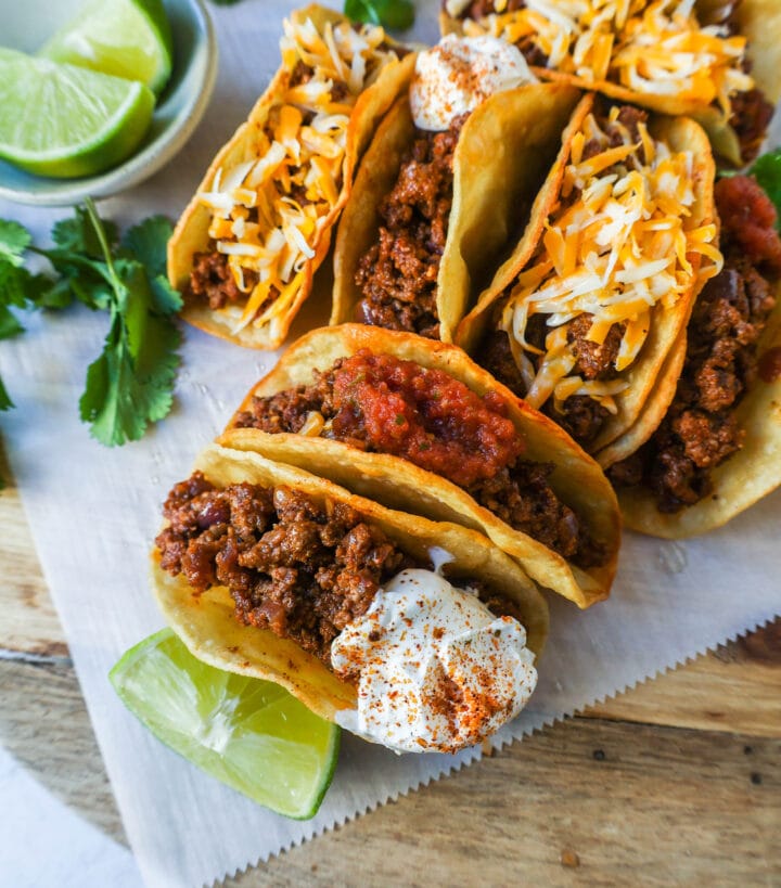 These homemade Ground Beef Tacos are made with spiced taco meat loaded into fried taco shells. Top with your favorite toppings for an easy 30-minute meal!