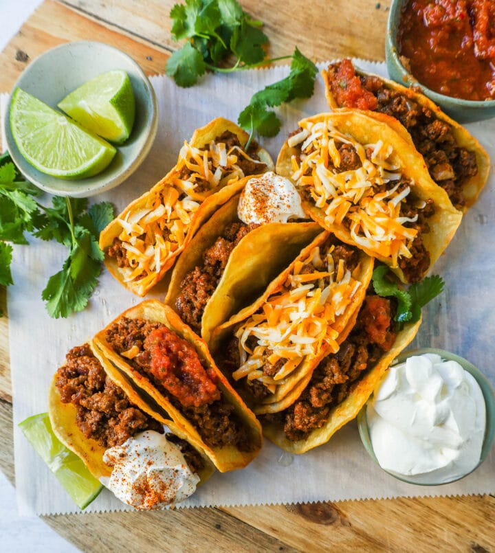 These homemade Ground Beef Tacos are made with spiced taco meat loaded into fried taco shells. Top with your favorite toppings for an easy 30-minute meal!