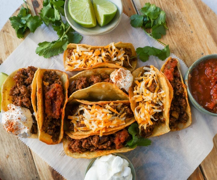 These homemade Ground Beef Tacos are made with spiced taco meat loaded into fried taco shells. Top with your favorite toppings for an easy 30-minute meal!