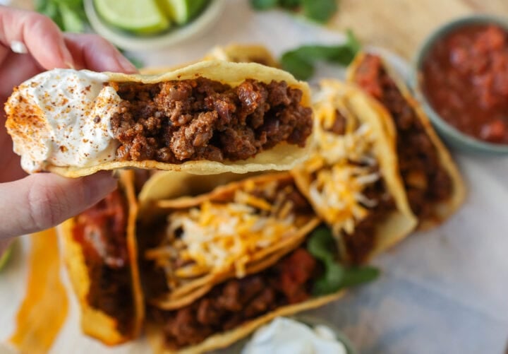 These homemade Ground Beef Tacos are made with spiced taco meat loaded into fried taco shells. Top with your favorite toppings for an easy 30-minute meal!