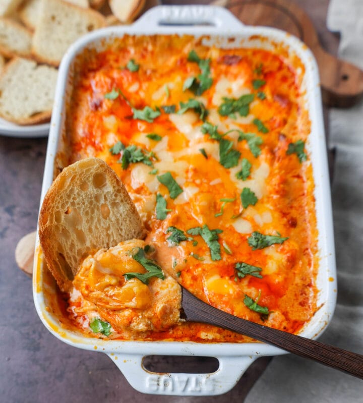 This Hot Creamy Buffalo Chip Dip is made with tender shredded chicken, cream cheese, buffalo sauce, ranch dressing, and topped with cheese, and baked until warm and bubbly.