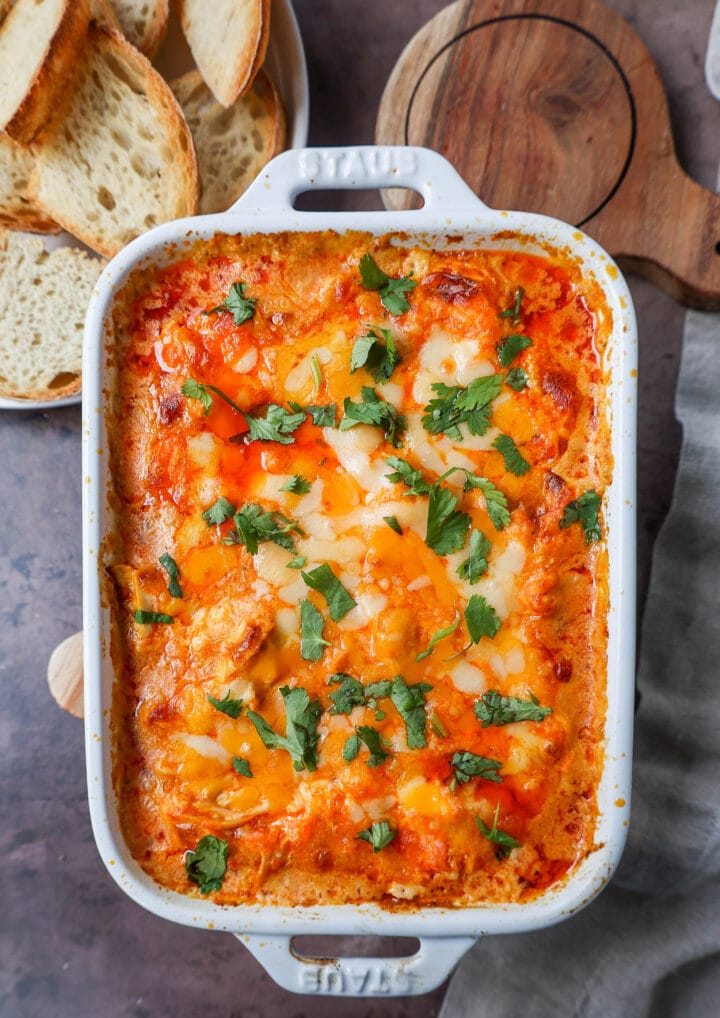 This Hot Creamy Buffalo Chip Dip is made with tender shredded chicken, cream cheese, buffalo sauce, ranch dressing, and topped with cheese, and baked until warm and bubbly.