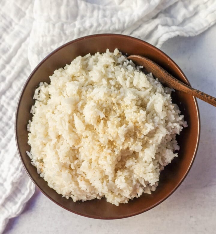 This Coconut Rice recipe is made with only five ingredients -- rice, coconut milk, water, sugar, and salt. It is the perfect savory side dish with a touch of coconut flavor.