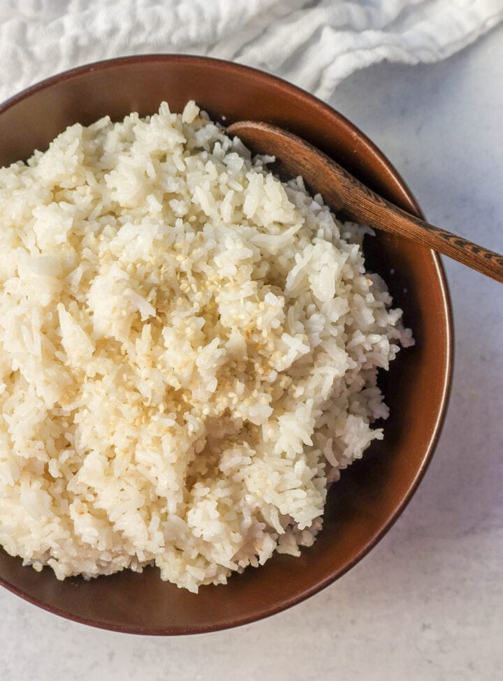 This Coconut Rice recipe is made with only five ingredients -- rice, coconut milk, water, sugar, and salt. It is the perfect savory side dish with a touch of coconut flavor.