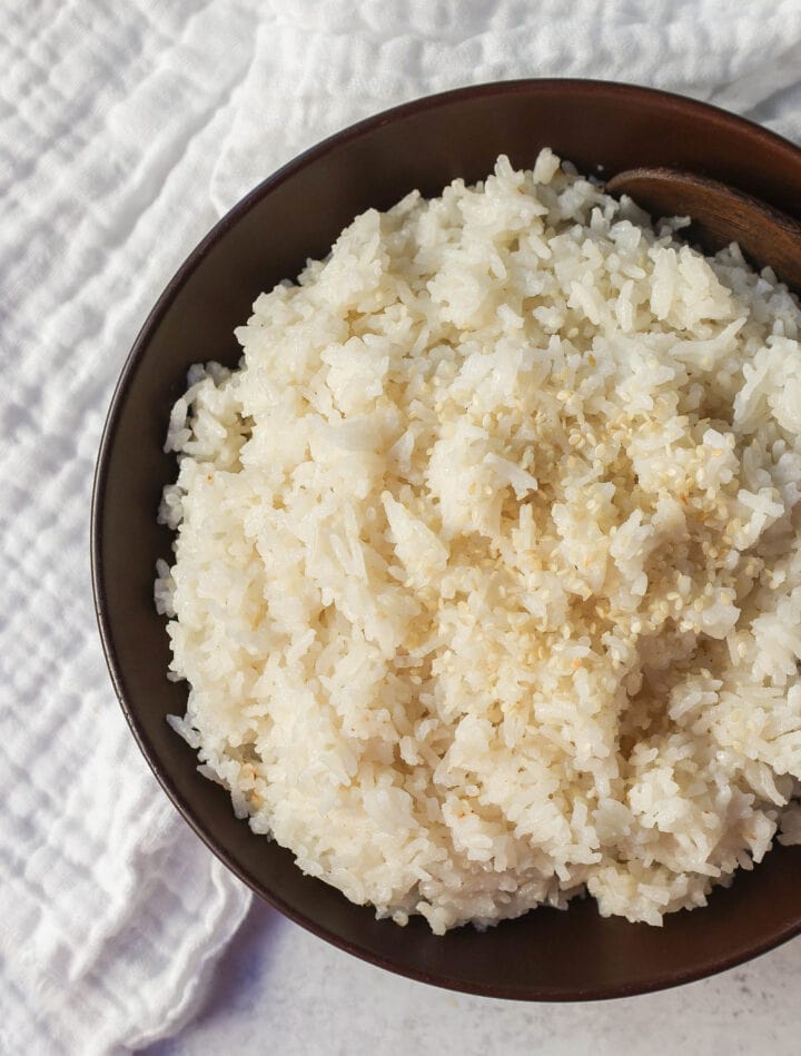 This Coconut Rice recipe is made with only five ingredients -- rice, coconut milk, water, sugar, and salt. It is the perfect savory side dish with a touch of coconut flavor.