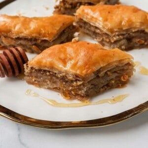 This is the best Baklava recipe made with layers of crisp, flaky, and buttery phyllo dough with crunchy cinnamon walnuts and soaked in sweet honey syrup. This is the most popular Greek dessert for good reason. Here are step-by-step instructions for making homemade Greek Baklava.