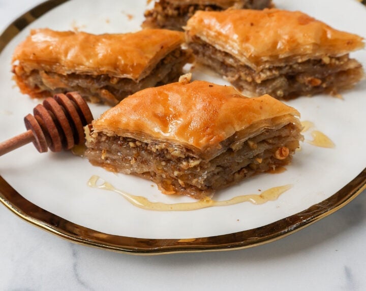 This is the best Baklava recipe made with layers of crisp, flaky, and buttery phyllo dough with crunchy cinnamon walnuts and soaked in sweet honey syrup. This is the most popular Greek dessert for good reason. Here are step-by-step instructions for making homemade Greek Baklava.