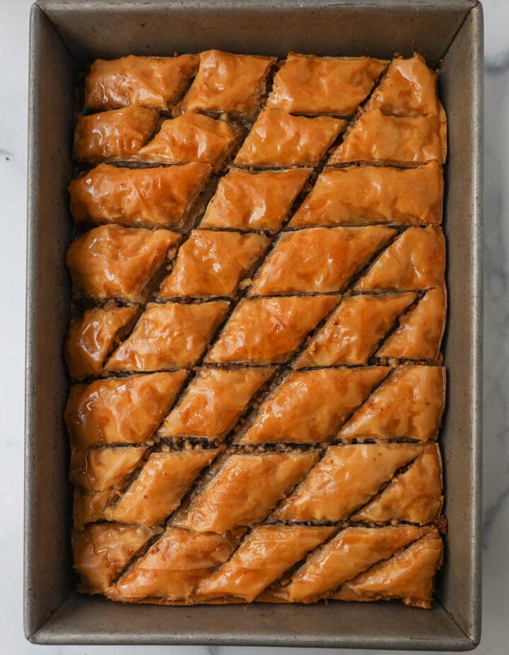 This is the best Baklava recipe made with layers of crisp, flaky, and buttery phyllo dough with crunchy cinnamon walnuts and soaked in sweet honey syrup. This is the most popular Greek dessert for good reason. Here are step-by-step instructions for making homemade Greek Baklava.