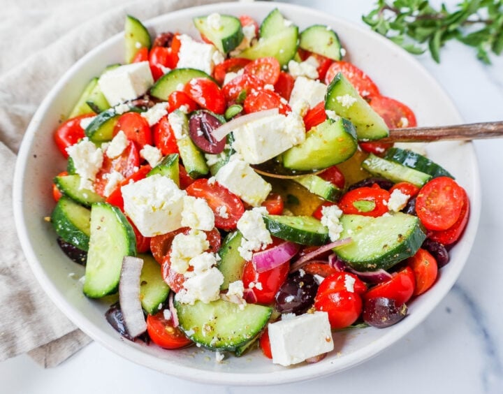 This simple Greek Salad is made with fresh tomatoes, cucumbers, red onion, kalamata olives, feta cheese, and all tossed with a homemade tangy Greek dressing. 