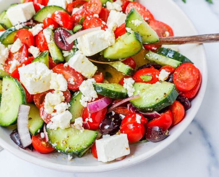 This simple Greek Salad is made with fresh tomatoes, cucumbers, red onion, kalamata olives, feta cheese, and all tossed with a homemade tangy Greek dressing. 