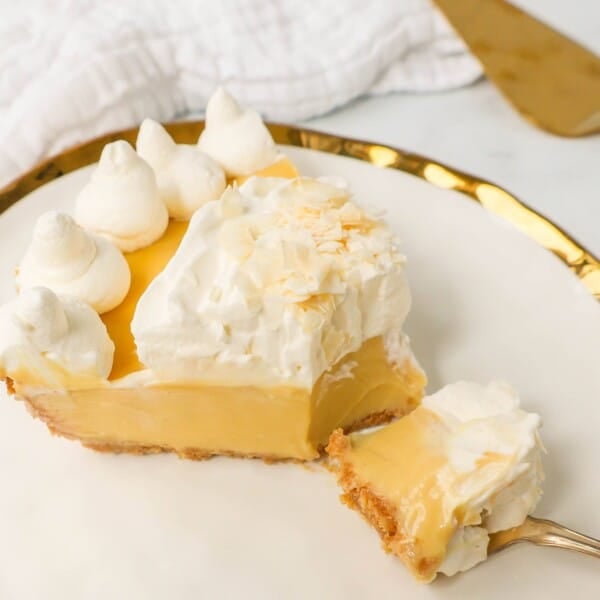 Creamy Passion Fruit Pie topped with fresh whipped cream is the perfect tropical cream pie recipe that will make you feel like you are in Hawaii! This Lilikoi Pie is similar to a key lime pie but made with passion fruit. This Passionfruit pie is made with a graham cracker crust, creamy passion fruit custard filling, and topped with billowy sweet whipped cream.