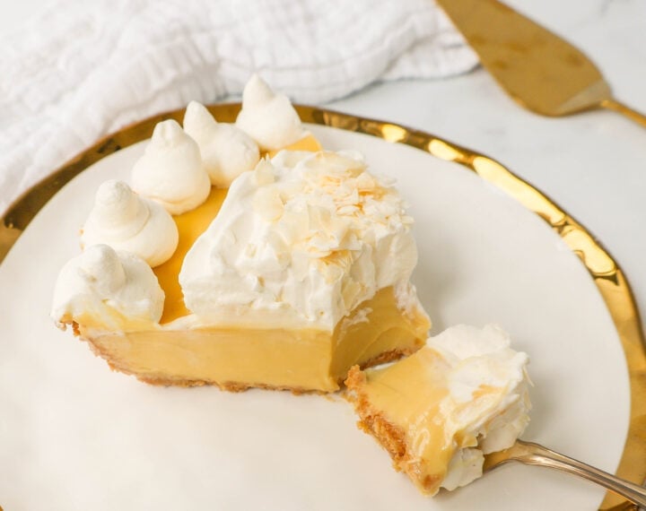 Creamy Passion Fruit Pie topped with fresh whipped cream is the perfect tropical cream pie recipe that will make you feel like you are in Hawaii! This Lilikoi Pie is similar to a key lime pie but made with passion fruit. This Passionfruit pie is made with a graham cracker crust, creamy passion fruit custard filling, and topped with billowy sweet whipped cream.