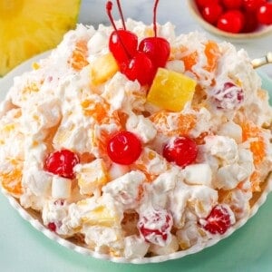 The Best Ambrosia Salad is a fluffy salad made with fresh pineapple, mandarin oranges, maraschino cherries, coconut, marshmallows, fresh whipped cream, a touch of sour cream, and sugar. This is a nostalgic, classic side dish or dessert recipe.