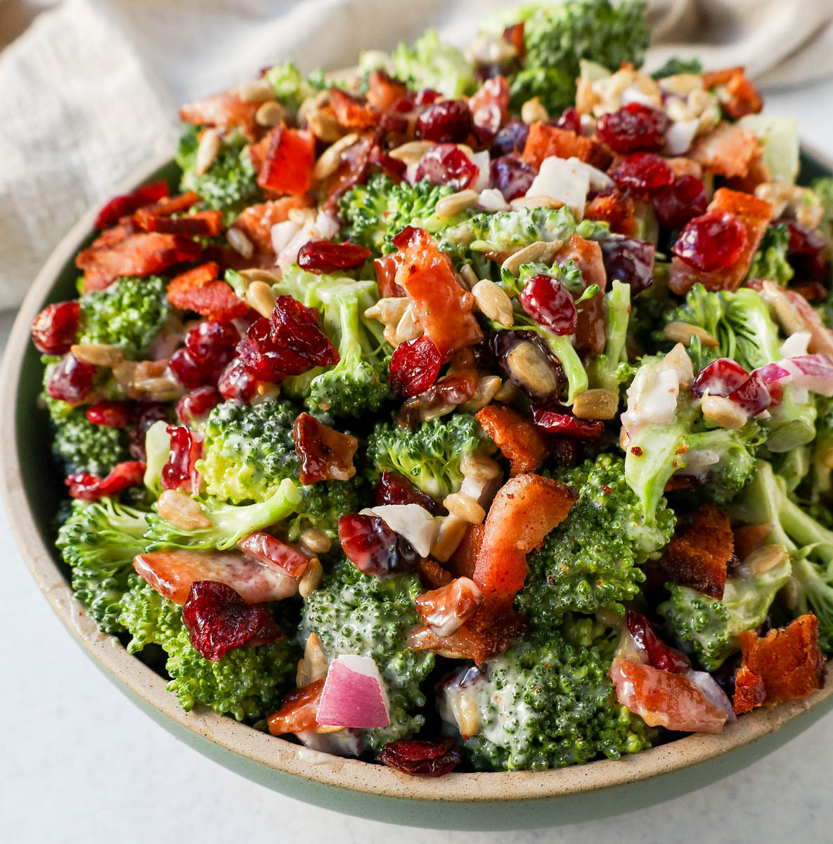 Crunchy, easy broccoli salad with crispy bacon, sweet dried cranberries, onion, and nuts all tossed in a sweet and tangy dressing. Tips for making the best broccoli salad. A classic potluck, BBQ, or summer side dish recipe!