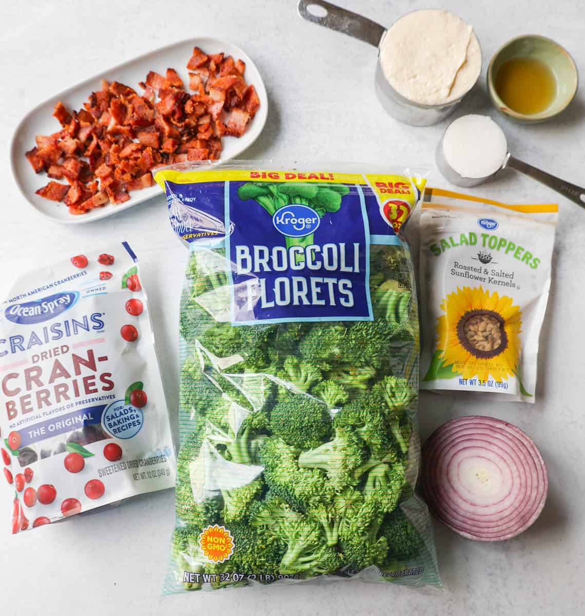 Broccoli Salad Ingredients. What Ingredients go in broccoli salad. Broccoli Salad made with bacon, cranberries, onion, nuts, and sweet and tangy dressing.