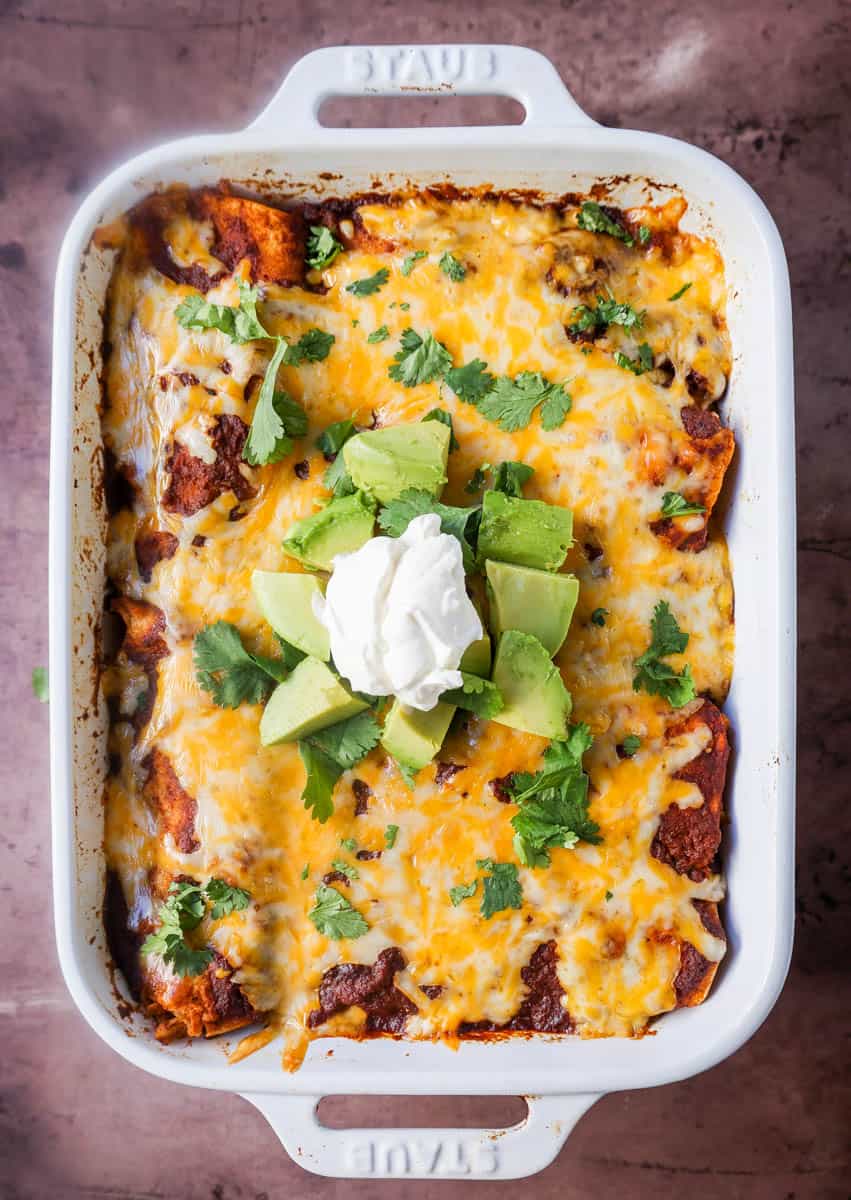 Chicken enchiladas with red sauce are made with soft and savory corn tortillas, shredded chicken, warm and flavorful red sauce from scratch and topped with Mexican crema and cheese