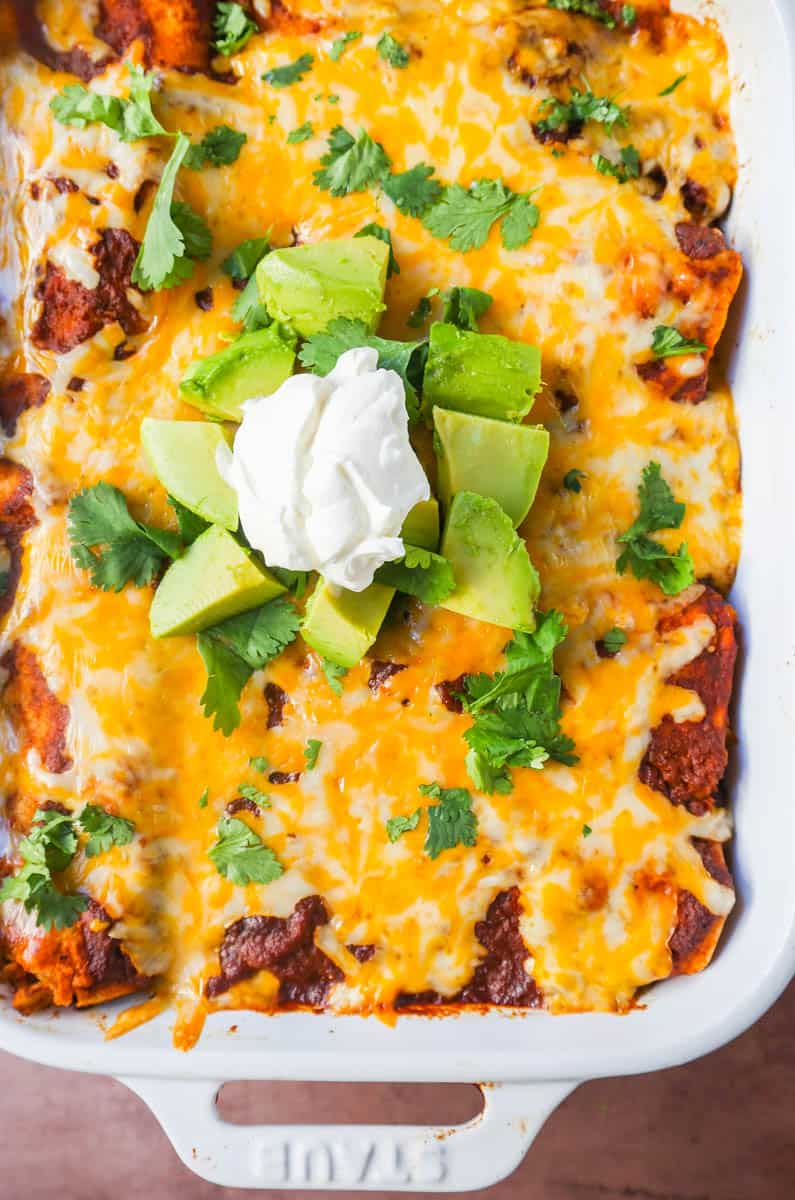 Chicken enchiladas with red sauce are made with soft and savory corn tortillas, shredded chicken, warm and flavorful red sauce from scratch and topped with Mexican crema and cheese