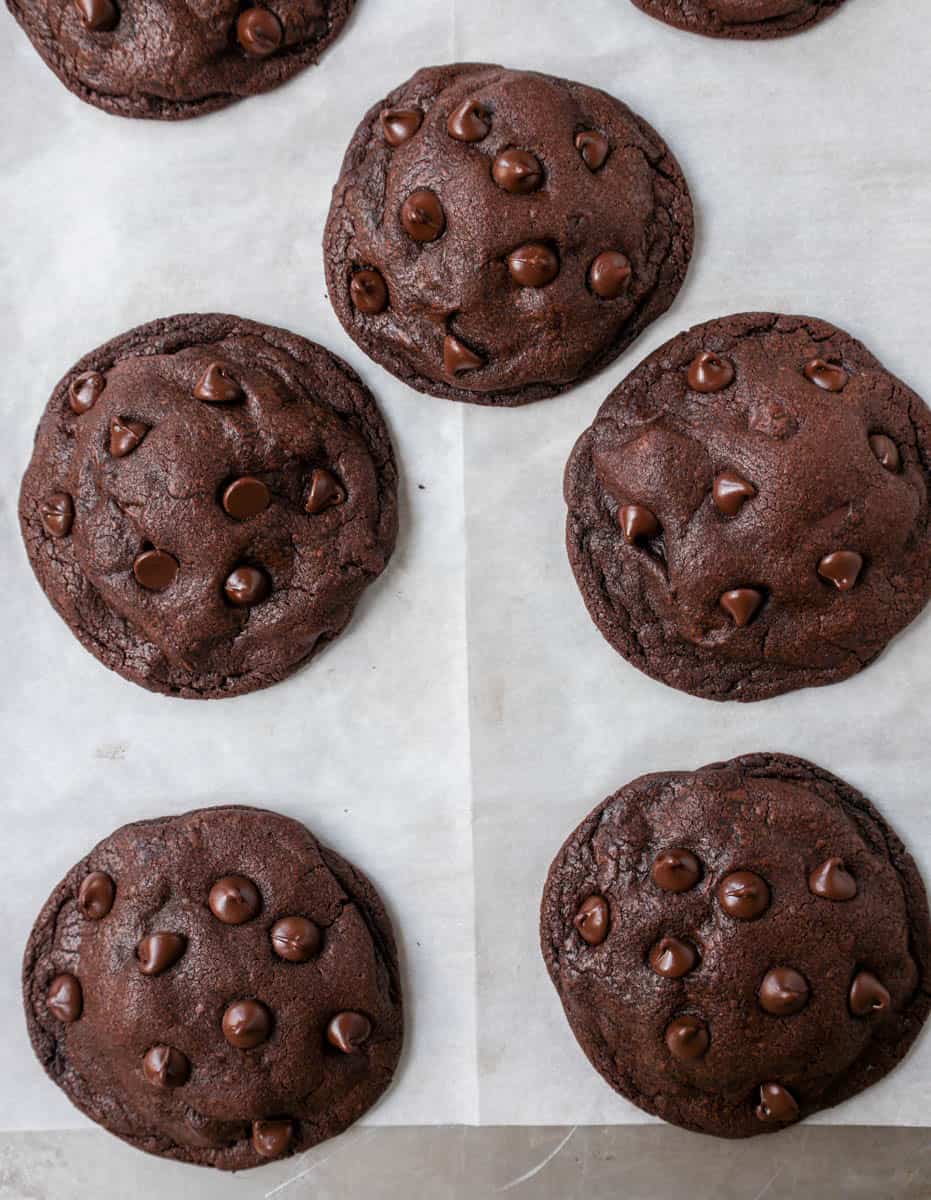 Chocolate Cookies on parchment paper on light colored baking sheet.