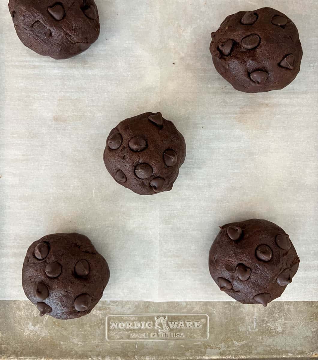 Balls of cookie dough placed on a baking sheet.