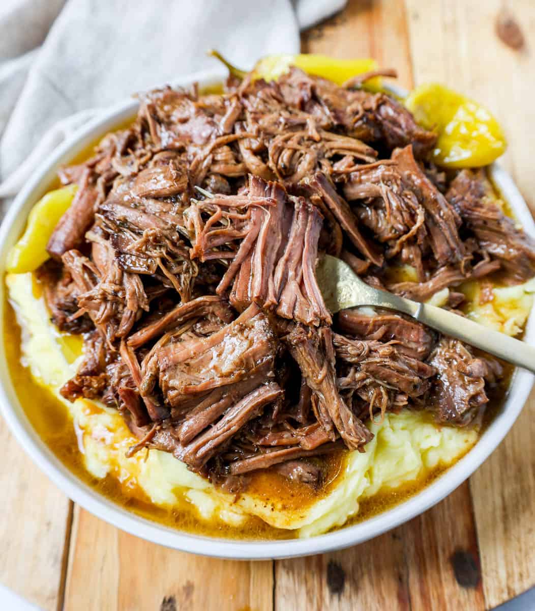 This Mississippi Pot Roast Recipe is the most tender, flavorful, melt-in-your-mouth beef roast recipe and is made with only five ingredients. This is the best beef pot roast recipe ever and is slow cooked in a crockpot.