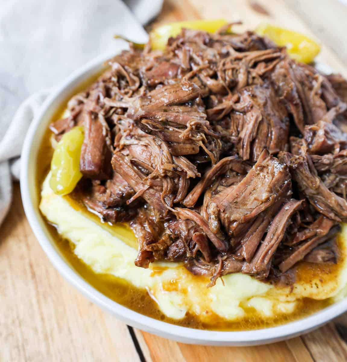 This Mississippi Pot Roast Recipe with mashed potatoes is the most tender, flavorful, melt-in-your-mouth beef roast recipe and is made with only five ingredients. This is the best beef pot roast recipe ever and is slow cooked in a crockpot.
