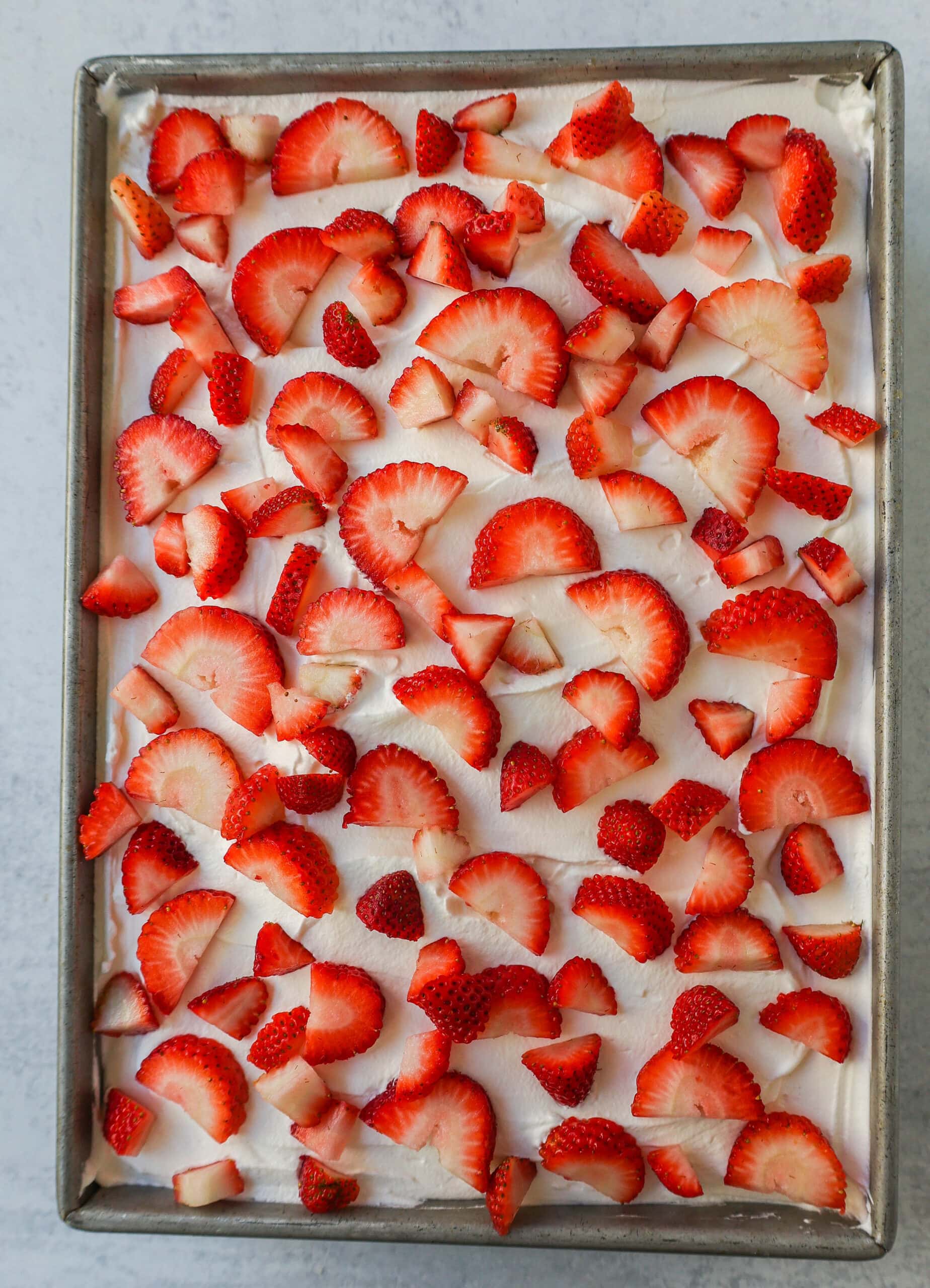 This Strawberry Cream Crunch Cake is a strawberry cake soaked with sweetened condensed milk after baking and topped with fresh sweet whipped cream, fresh strawberries, and crushed golden Oreos for crunch. This strawberry poke cake has it all!