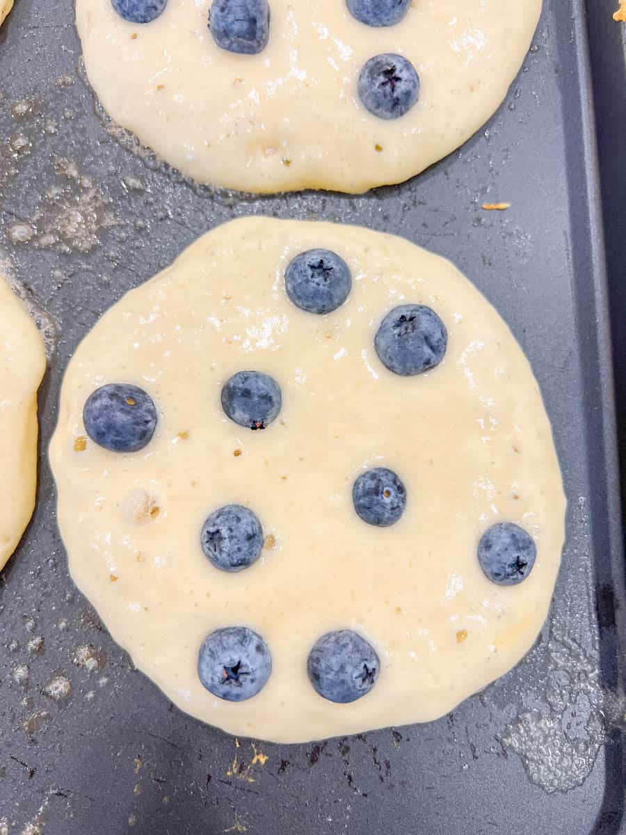 Homemade fluffy blueberry pancakes are made with fresh blueberries and are the best buttermilk blueberry pancakes ever! These are easy blueberry pancakes made from scratch. 