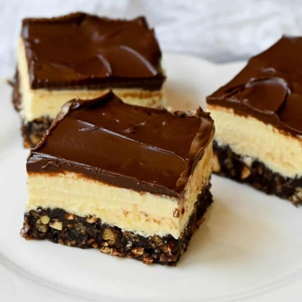 Rich and fudgy Nanaimo bars are the perfect no bake dessert. A chocolate, graham cracker, almond, and coconut base layer is topped with a creamy custard filling and chocolate ganache. You’ll be hooked on this classic Canadian treat!