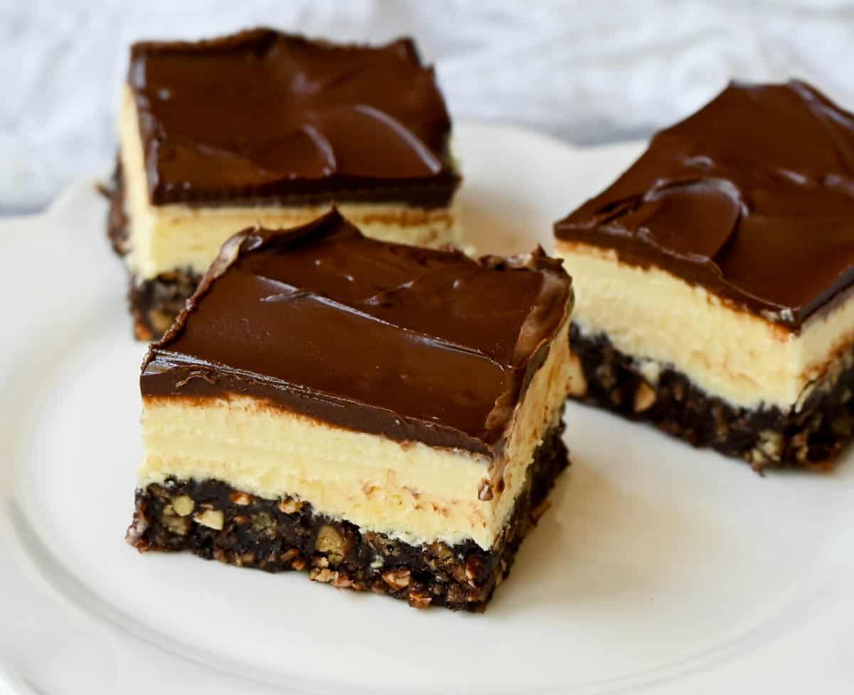 Rich and fudgy Nanaimo bars are the perfect no bake dessert. A chocolate, graham cracker, almond, and coconut base layer is topped with a creamy custard filling and chocolate ganache. You’ll be hooked on this classic Canadian treat!