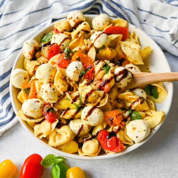 This Caprese Tortellini is made with cheese Tortellini tossed with sauteed garlic and tomatoes in extra virgin olive oil, fresh basil, and fresh mozzarella and spices. This fresh tortellini caprese pasta is perfect for summer!