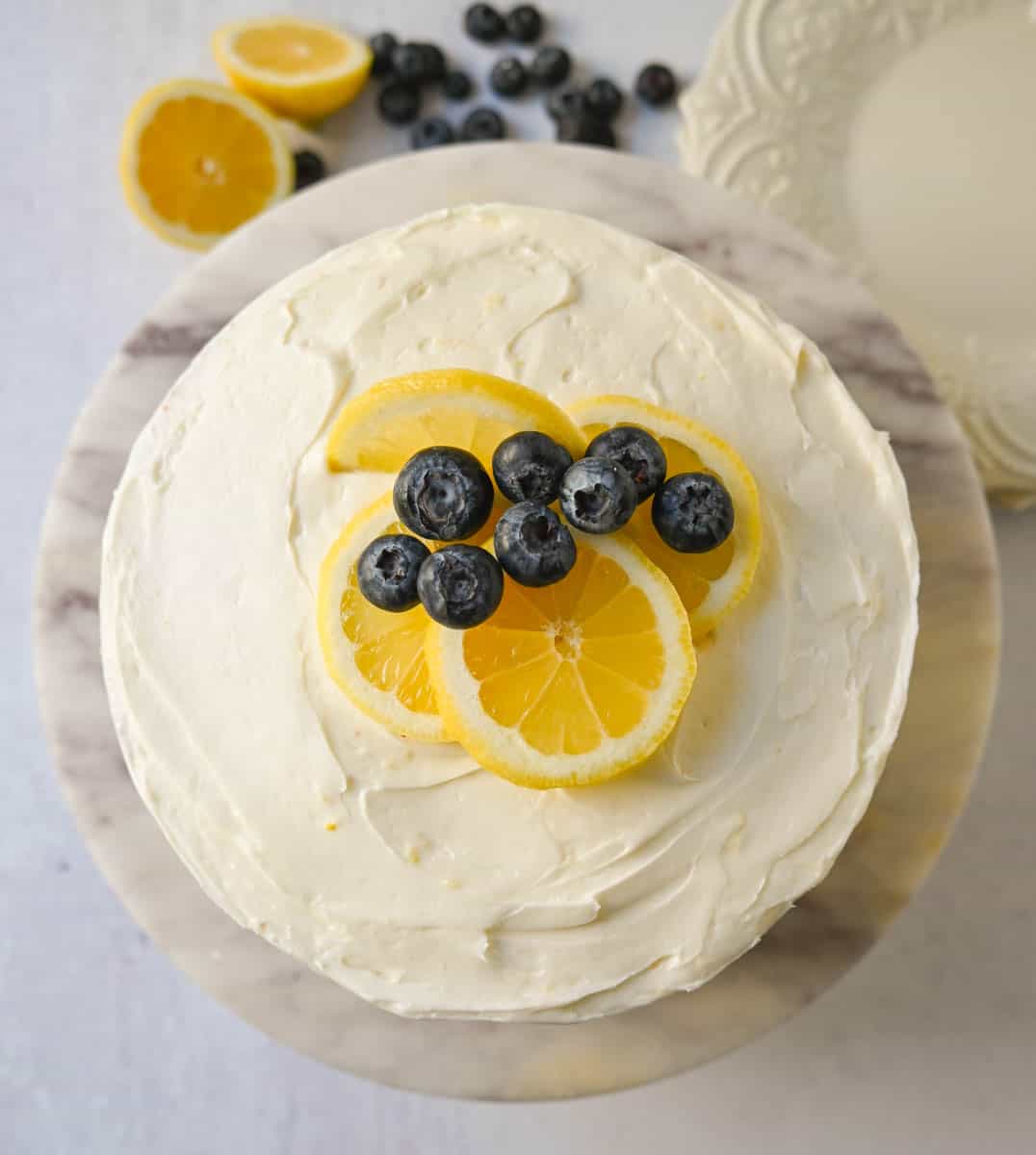 Light, fluffy, moist lemon cake with with fresh blueberries with a sweet cream cheese frosting. This is the best lemon blueberry cake recipe!