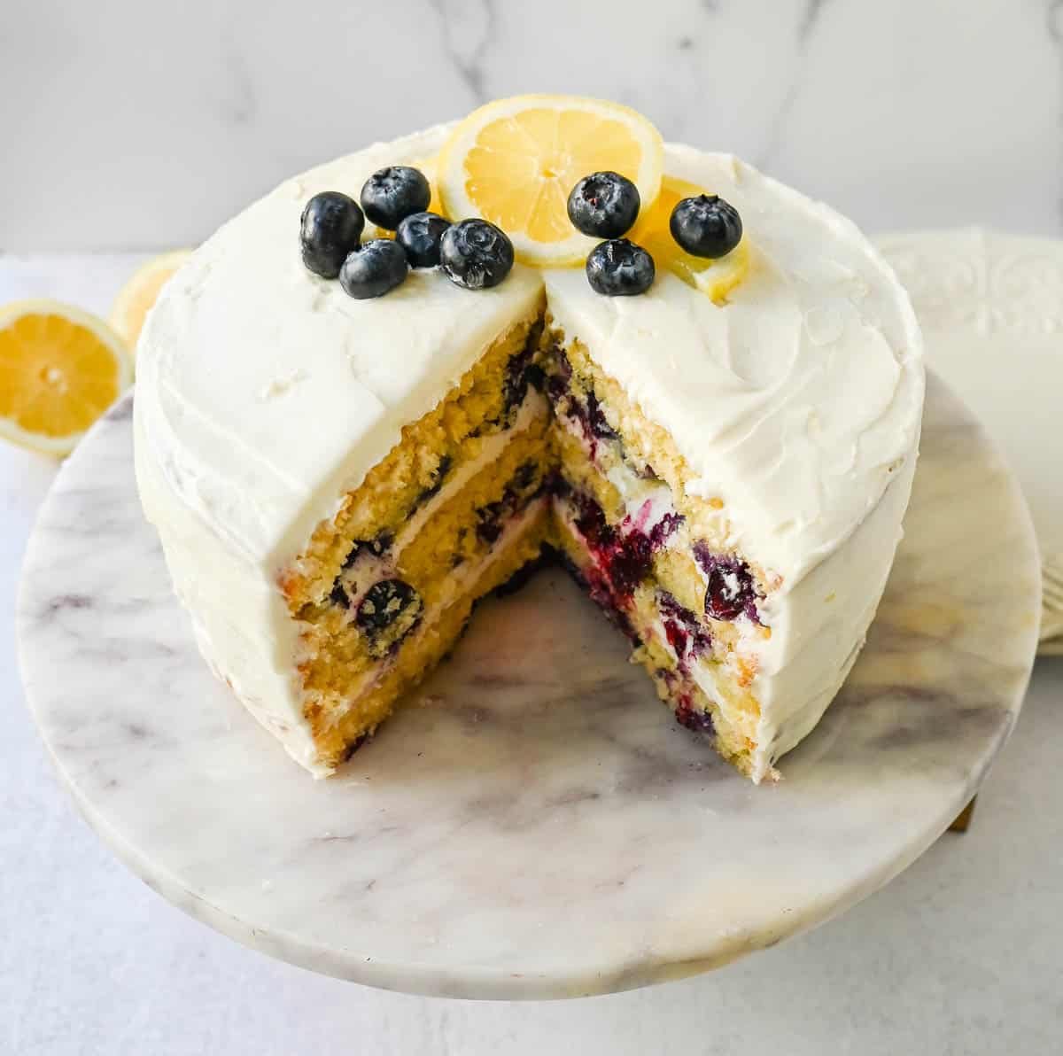 Light, fluffy, moist lemon cake with with fresh blueberries with a sweet cream cheese frosting. This is the best lemon blueberry cake recipe!