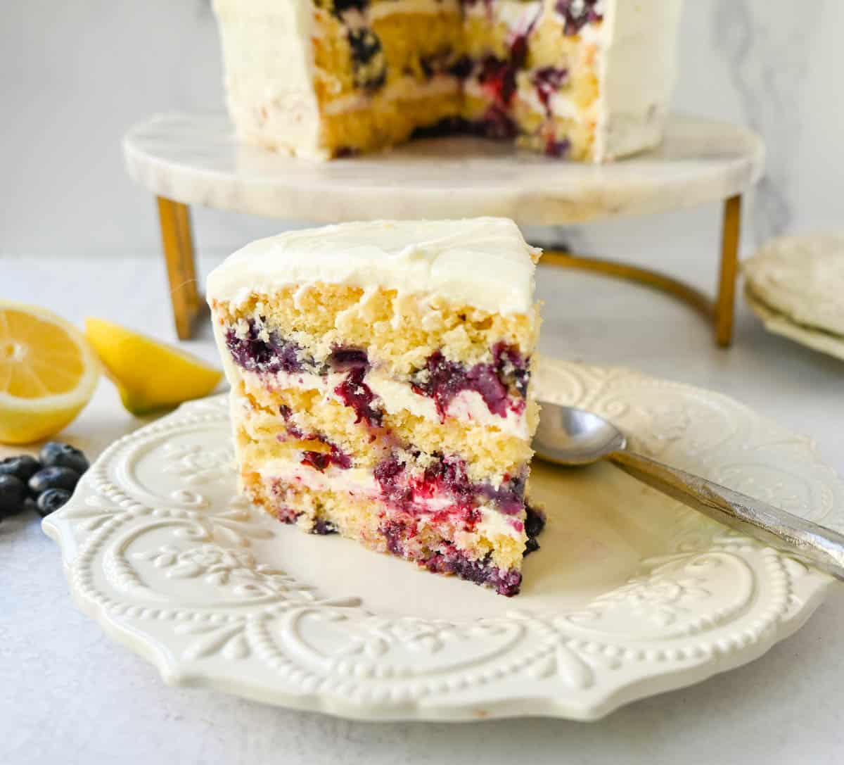 Light, fluffy, moist lemon cake with with fresh blueberries with a sweet cream cheese frosting. This is the best lemon blueberry cake recipe!