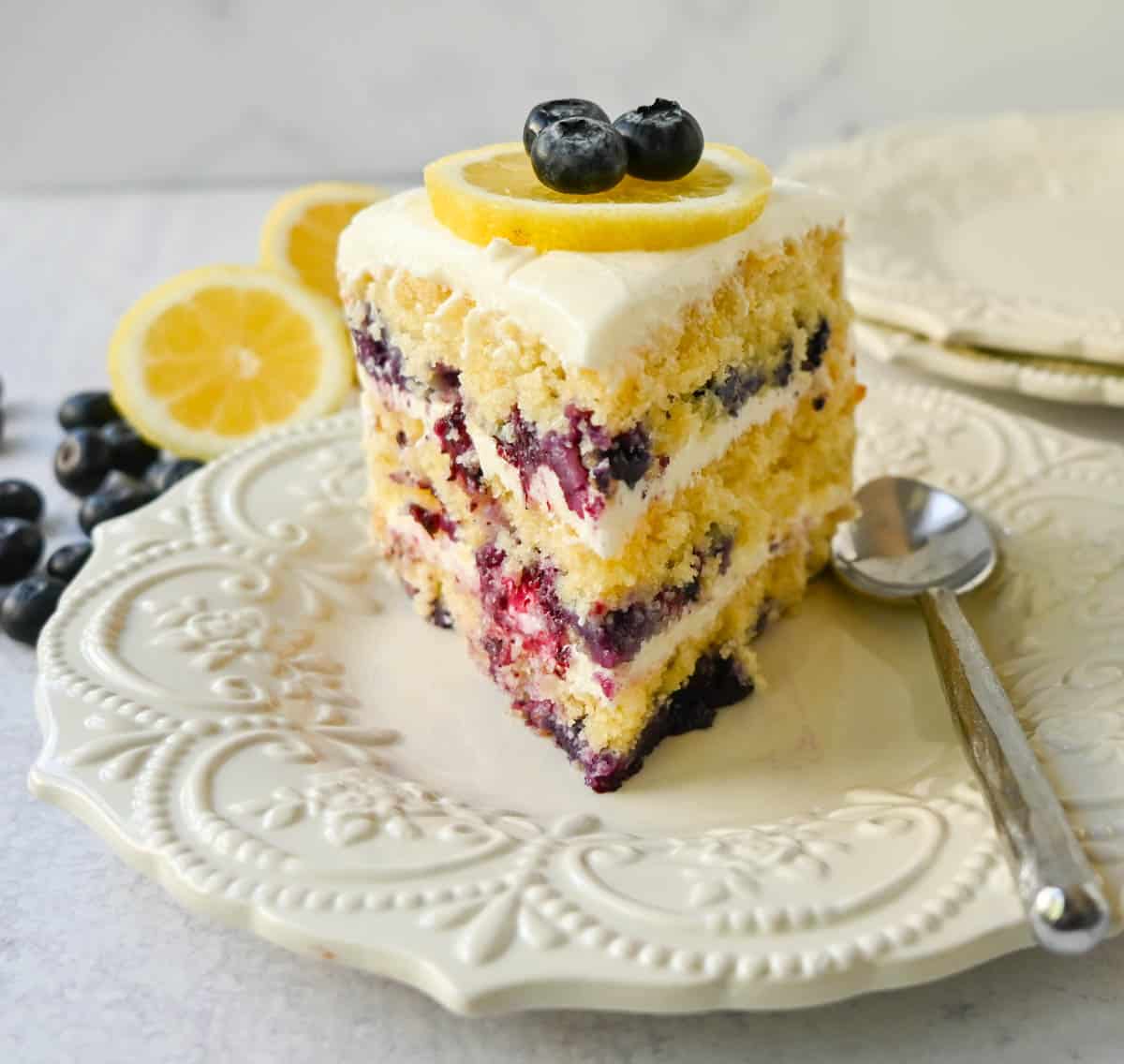 Light, fluffy, moist lemon cake with with fresh blueberries with a sweet cream cheese frosting. This is the best lemon blueberry cake recipe!