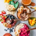 How to make a thick, creamy, fruity smoothie bowl at home. Here are all of the tips and tricks for making the best smoothie bowls. I am sharing 4 smoothie bowl recipes -- acai smoothie bowl, pitaya dragonfruit smoothie bowl, chocolate peanut butter banana smoothie bowl, and tropical pineapple coconut smoothie bowl.
