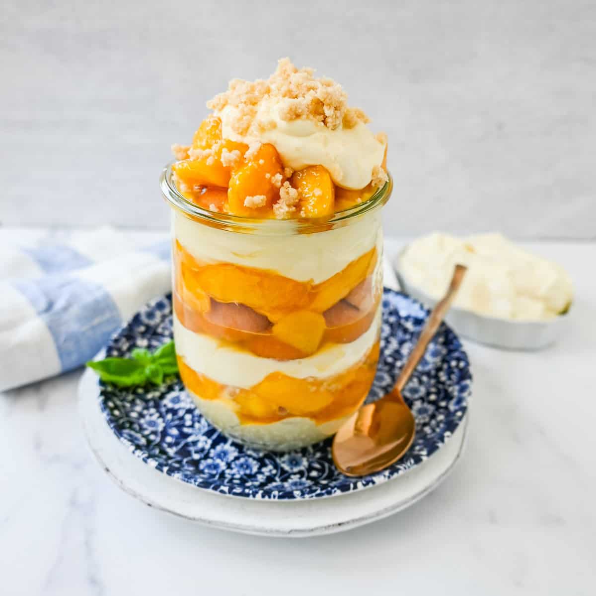 This summer dessert is made with fresh peaches in a creamy vanilla pudding and whipped cream with Nilla wafers and a buttery crumble topping. This Magnolia Bakery Peach Crisp Pudding will be your favorite no-bake summer dessert recipe. This peach trifle is like banana pudding but even better!