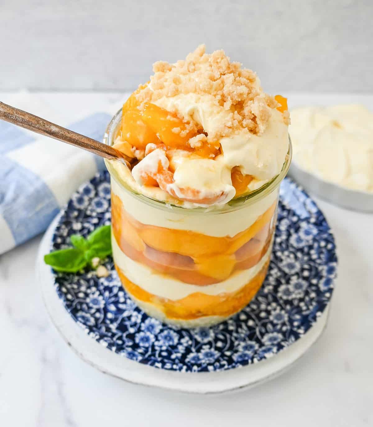 This summer dessert is made with fresh peaches in a creamy vanilla pudding and whipped cream with Nilla wafers and a buttery crumble topping. This Magnolia Bakery Peach Crisp Pudding will be your favorite no-bake summer dessert recipe. This peach trifle is like banana pudding but even better!