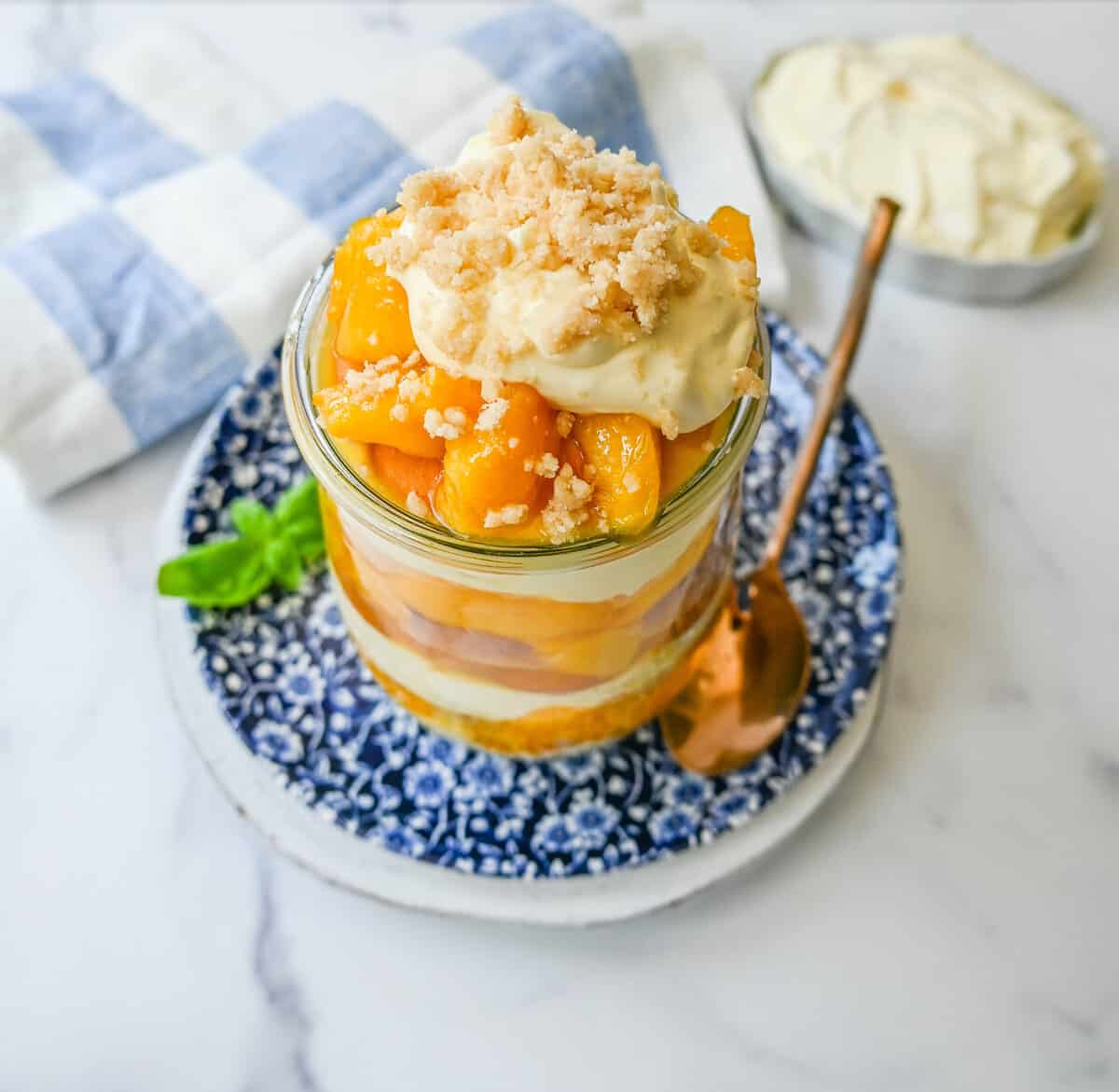 This summer dessert is made with fresh peaches in a creamy vanilla pudding and whipped cream with Nilla wafers and a buttery crumble topping. This Magnolia Bakery Peach Crisp Pudding will be your favorite no-bake summer dessert recipe. This peach trifle is like banana pudding but even better!