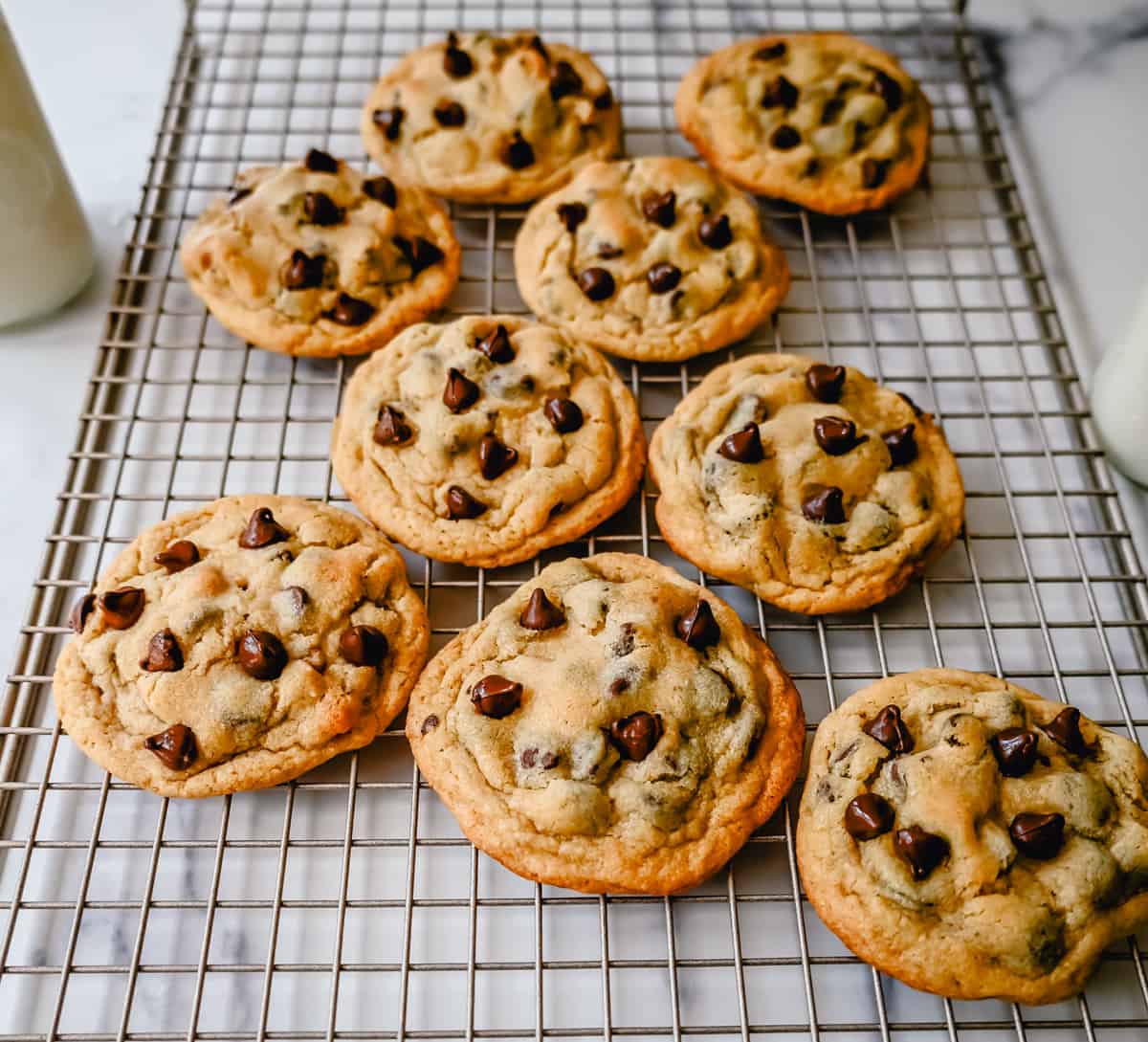 Placing chocolate chip cookies on a cooling rack to cool after baking