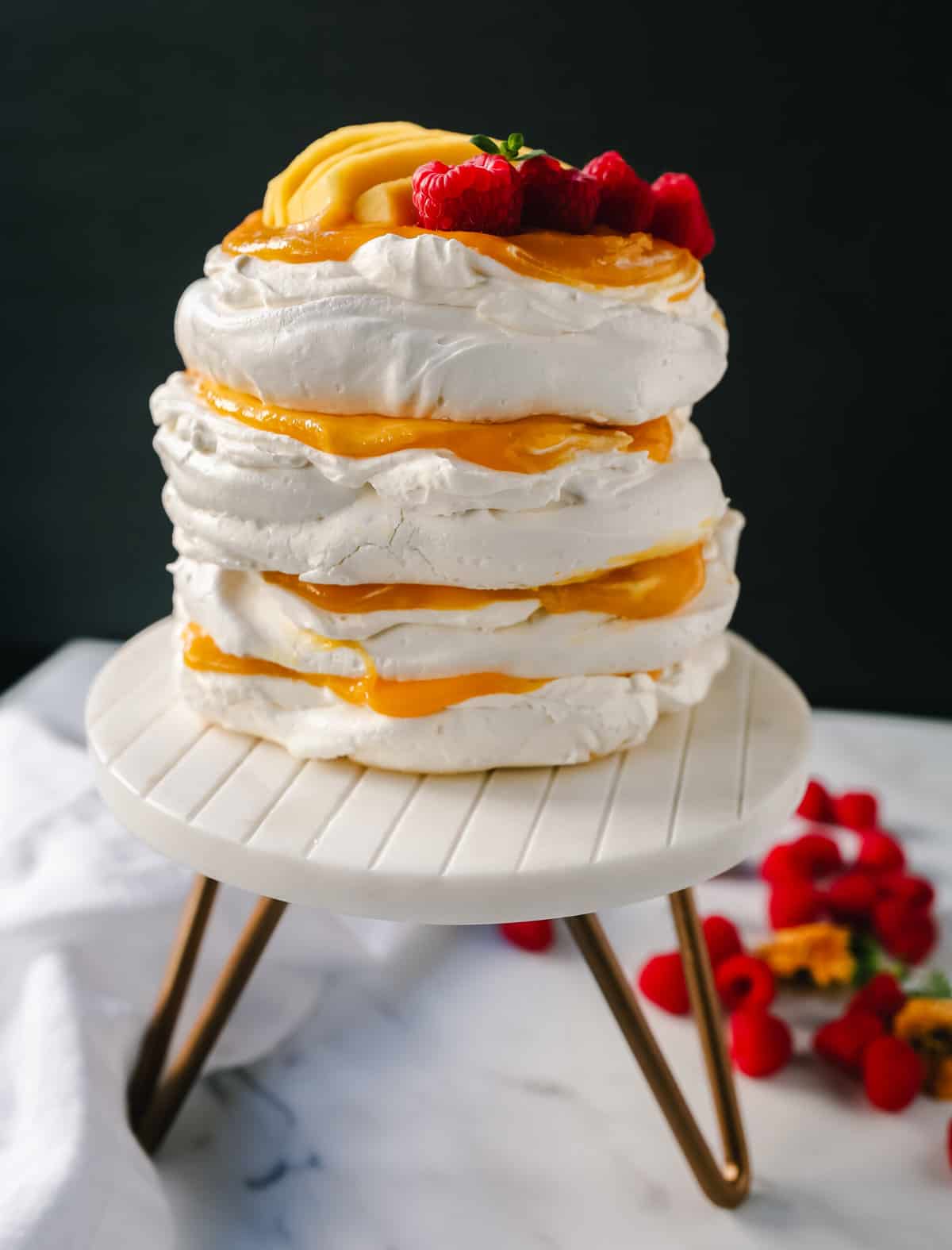 Pavlova. A stunning dessert with a crisp, crunchy outer shell with a soft, marshmallow-like center. Topped with fresh whipped cream and fresh fruit. It is a beautiful and delicious dessert to wow a crowd!
