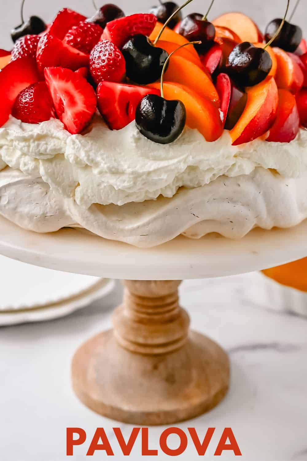 Pavlova. A stunning dessert with a crisp, crunchy outer shell with a soft, marshmallow-like center. Topped with fresh whipped cream and fresh fruit. It is a beautiful and delicious dessert to wow a crowd!