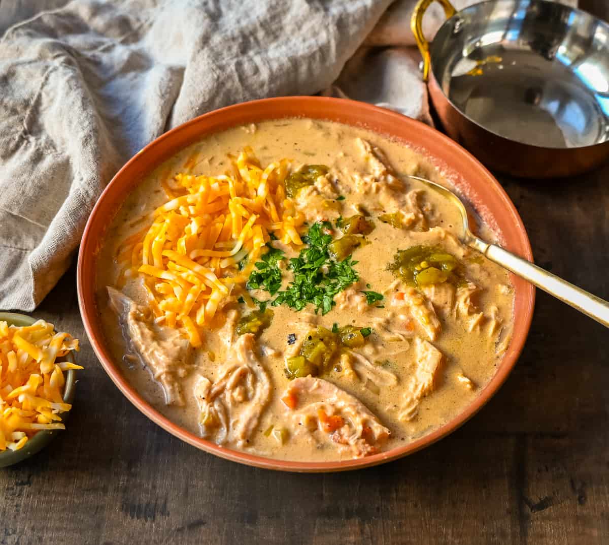 Rich, cheesy chicken queso soup made with three types of cheeses, tender chicken, green chiles, and spices—all the flavors of cheese queso but in a soup! The creamiest, most flavorful Chicken Cheese Soup.